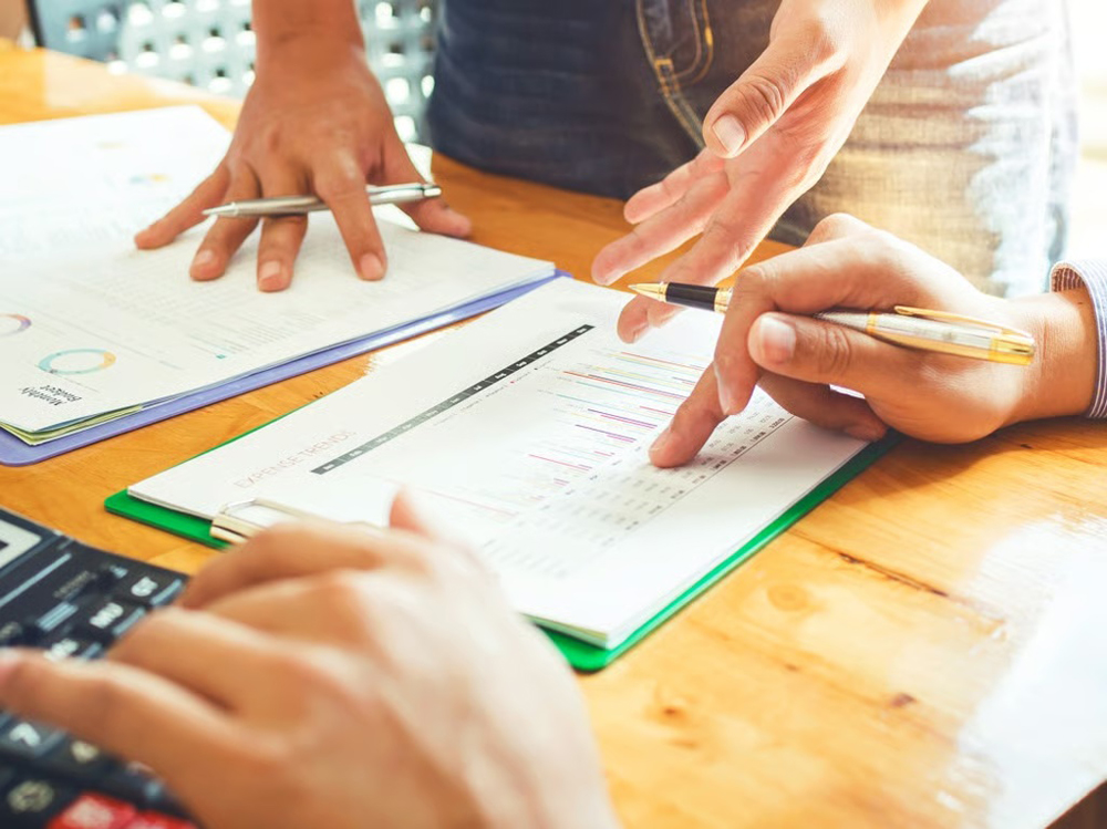 2 Personen mit Berechnungszettel und Stift 